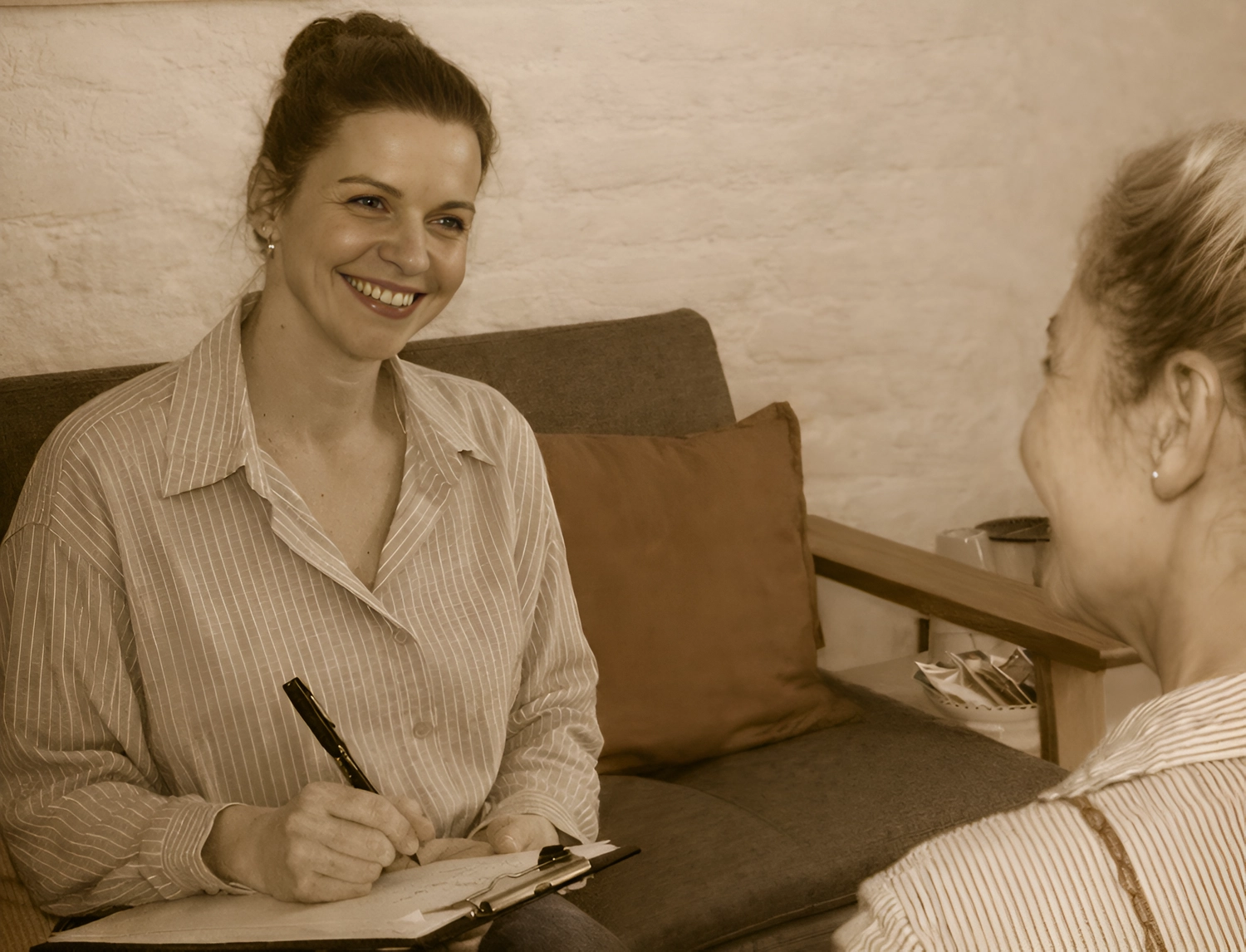 FO(U)R US – Beratung – Das Bild zeigt eine Person, die lächelnd Notizen während eines Gesprächs macht.